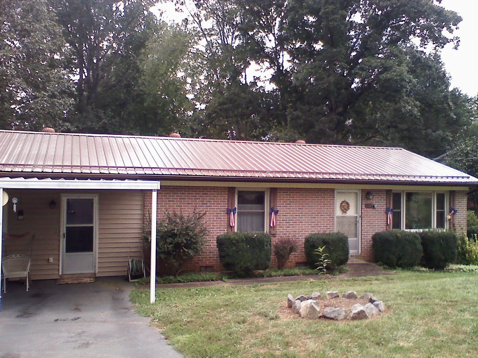 Bronze metal roof and carport on a brick ranch home — Roof Repair work by our crew in Jordan